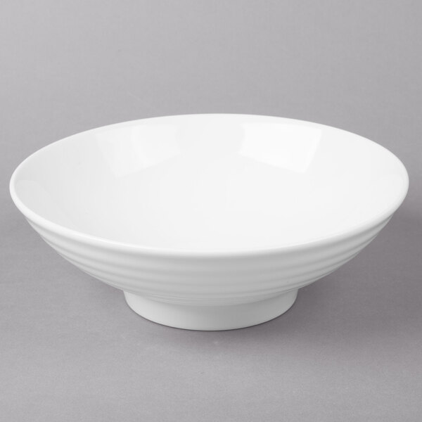A white 10 Strawberry Street Whittier ribbed footed bowl on a gray surface.
