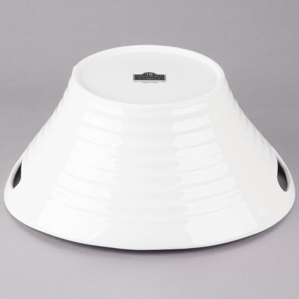 A white porcelain deep handle bowl with two handles.