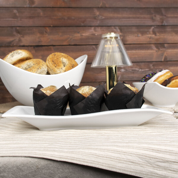 A table with a rectangular white porcelain platter of food on it.