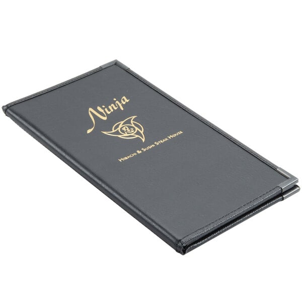 A black Menu Solutions Royal Select leather-like menu cover with gold writing on a table.