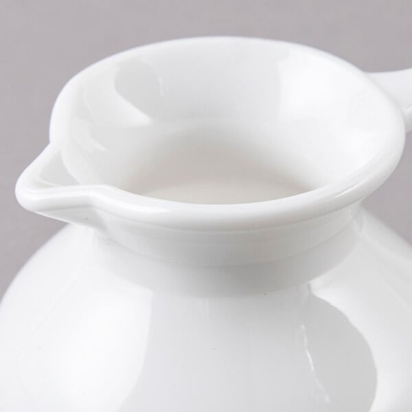 A white pitcher with a handle.