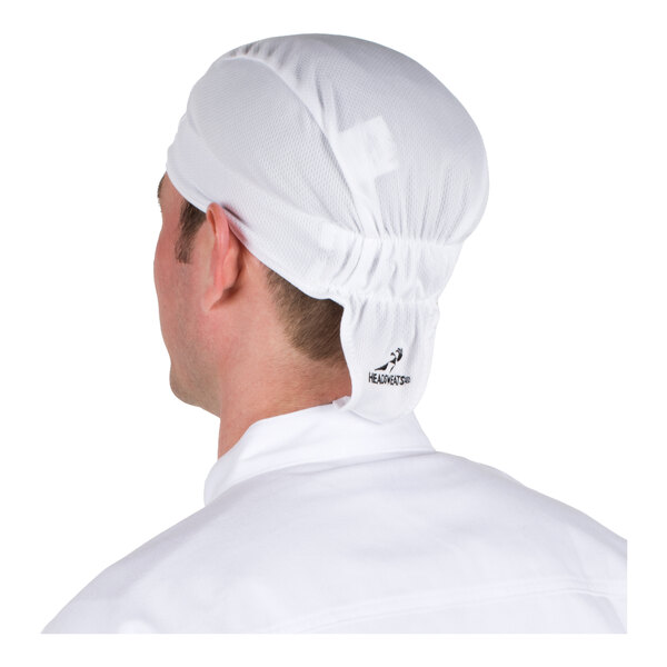 A person is wearing a white, fitted cap that covers the head and ties at the back, viewed from behind.