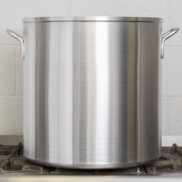 A large silver Vollrath Wear-Ever aluminum stock pot on a stove.