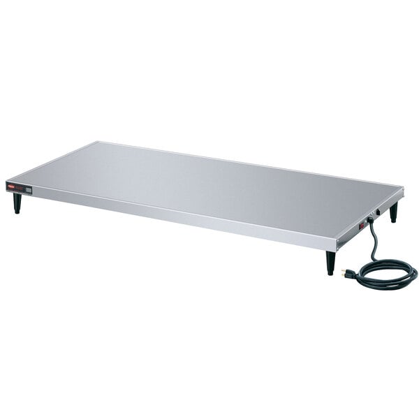 A rectangular stainless steel Hatco heated shelf on a table with a black cord.