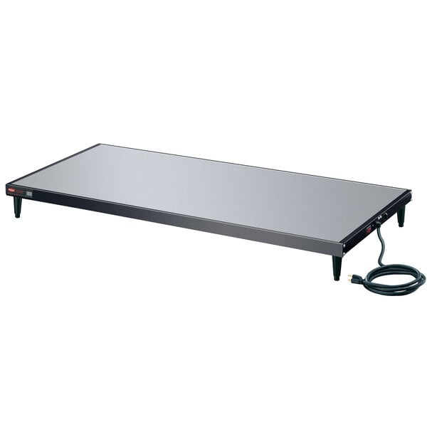 A black rectangular Hatco heated shelf with a black cord.