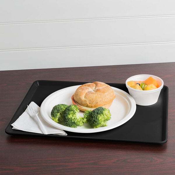A black Cambro dietary tray with a sandwich and broccoli on it.