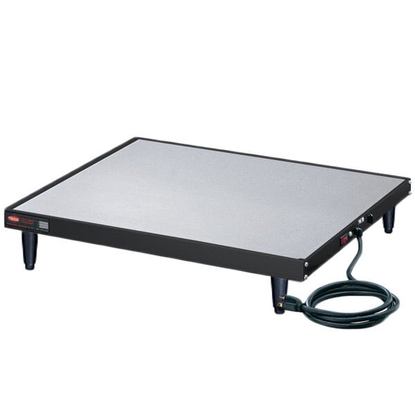 A black rectangular Hatco heated shelf with a cord on a table.