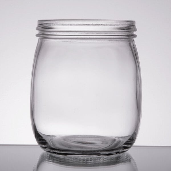 A clear glass American Metalcraft condiment mason jar with a lid on a table.
