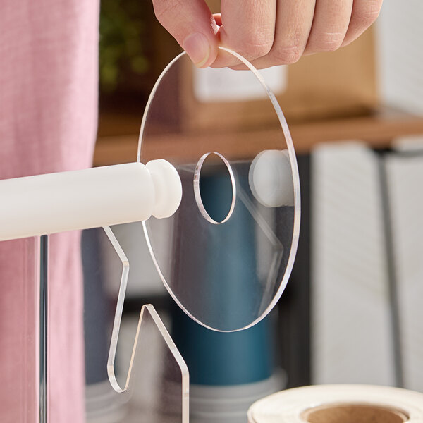 A clear plastic disk designed for use with a label dispenser.