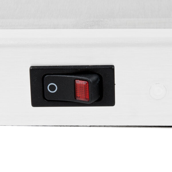 A close up of a red switch on a white surface.