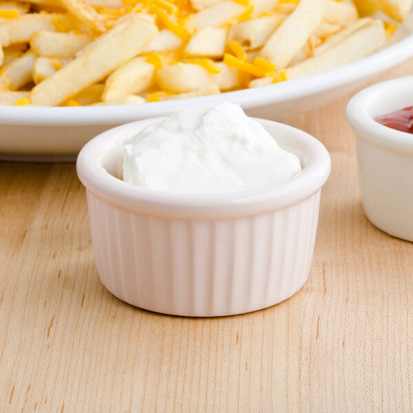 A white Tuxton fluted ramekin filled with white cream.