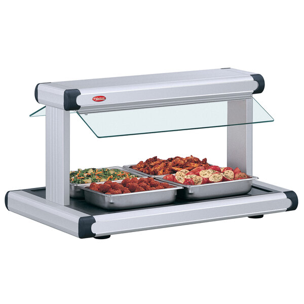 A Hatco buffet warmer with white granite food trays on a buffet counter.