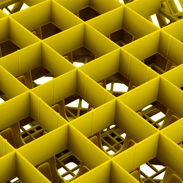 A yellow Vollrath Traex glass rack with square compartments.