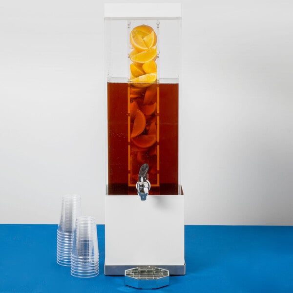 A Cal-Mil stainless steel beverage dispenser with an infusion chamber and plastic cups.