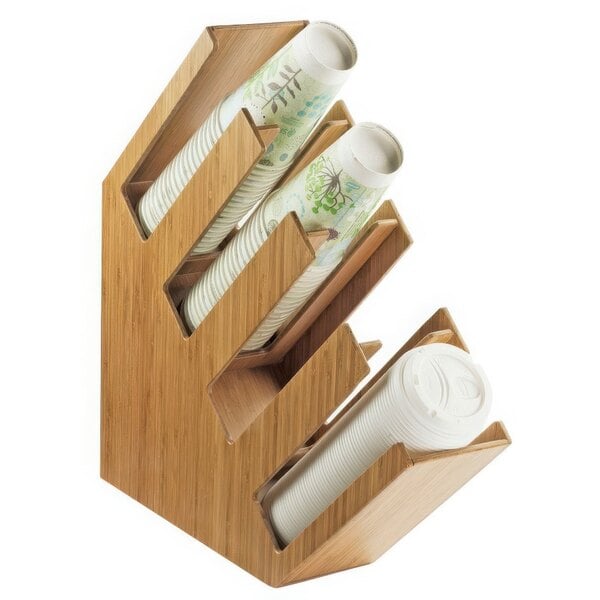 A Cal-Mil bamboo slanted countertop cup and lid organizer with white plastic cups in it.