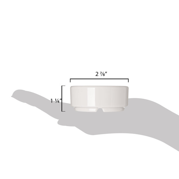 A hand holding a Carlisle ivory bone melamine ramekin with a black border.