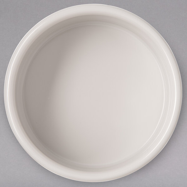 A Carlisle ivory bone ramekin on a white surface with black lines.