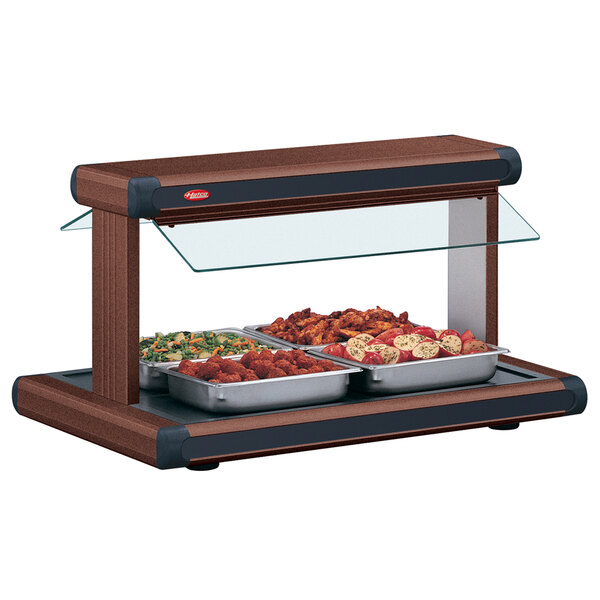 A Hatco countertop buffet warmer with food in trays on a table.