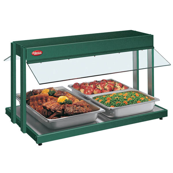 A Hatco green buffet warmer with trays of meat and vegetables inside.