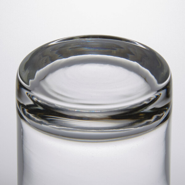 An Arcoroc beverage glass filled with water on a white background.