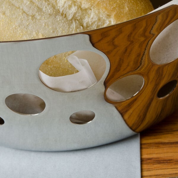 A Tablecraft stainless steel round serving basket with a piece of bread inside.