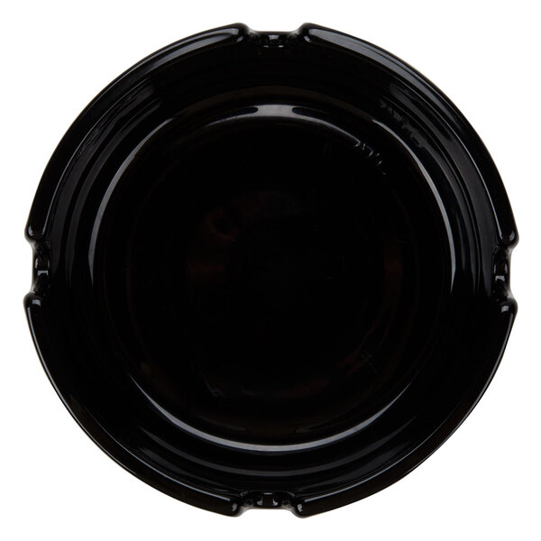 A black Arcoroc glass ashtray with a rim.