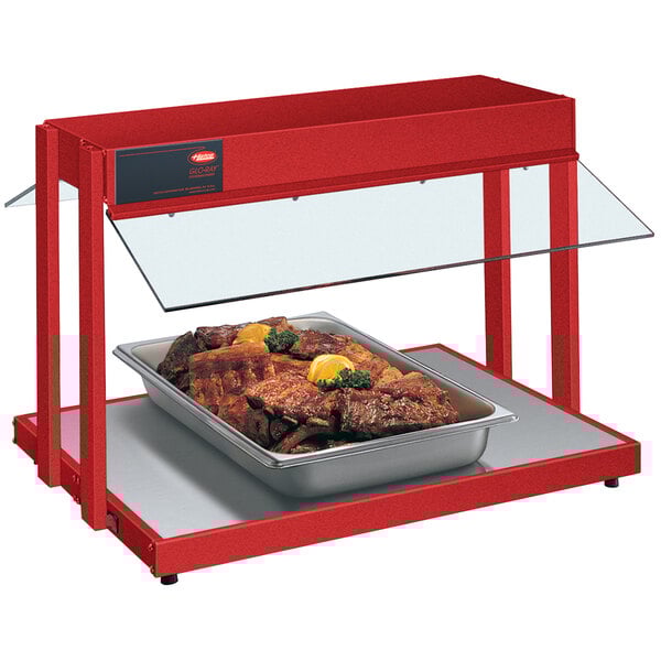 A Hatco red Glo-Ray countertop buffet warmer with a tray of meat and lemon wedges.