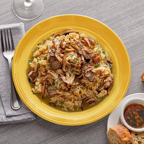 A Tuxton Concentrix saffron china plate with rice and meat on it.