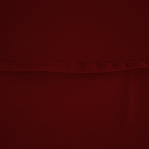 A close up of a burgundy fabric table cover.
