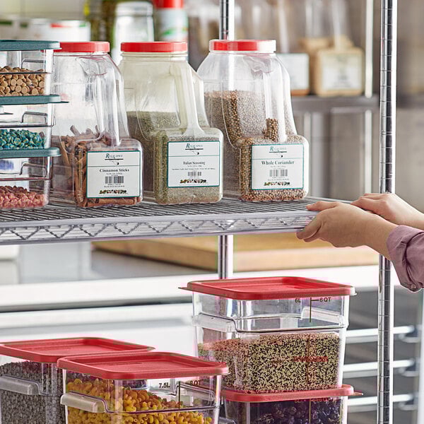 A person reaching for a shelf with clear label holders holding containers of food.