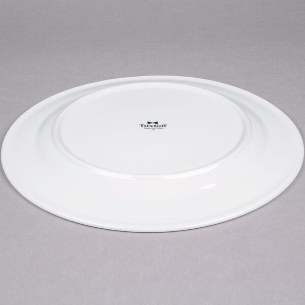 A Tuxton Alaska bright white china plate with a wide rim.