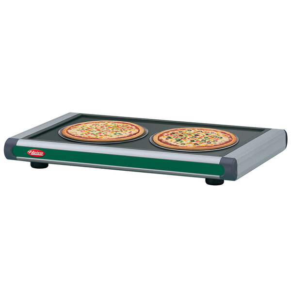 A Hatco Glo-Ray heated shelf with two pizzas on it.