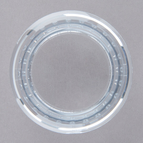 A clear plastic circle with holes.