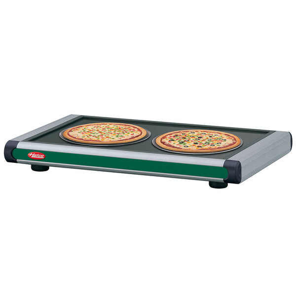 A Hatco heated shelf with two pizzas on it.
