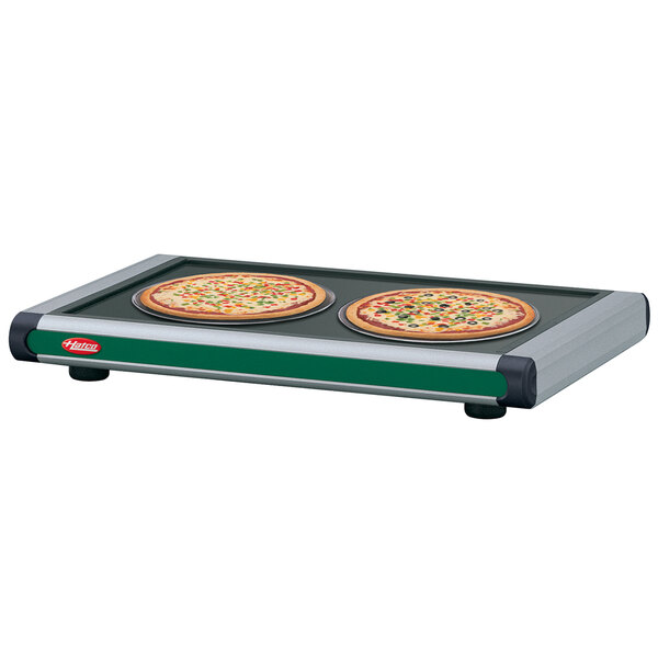 A Hatco heated shelf with pizzas on it in a pizza parlor.