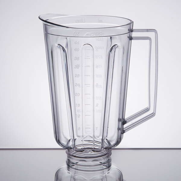 A clear plastic blender jar with handle and lid.