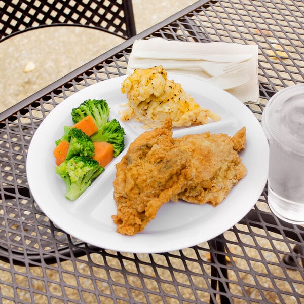 A Carlisle white melamine plate with broccoli and carrots on it.