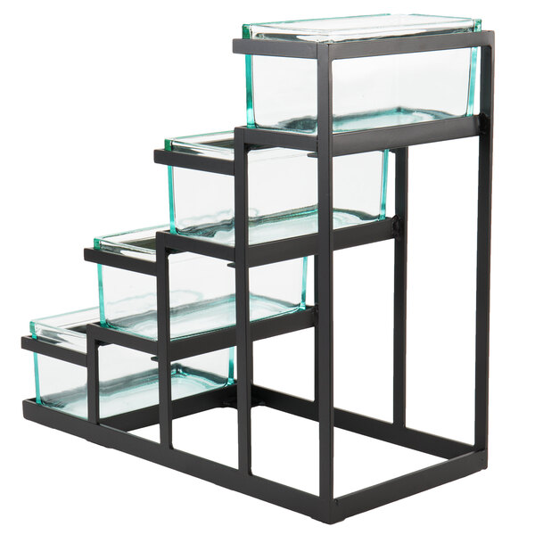 A black metal Cal-Mil stair step condiment display with glass jars on glass shelves.