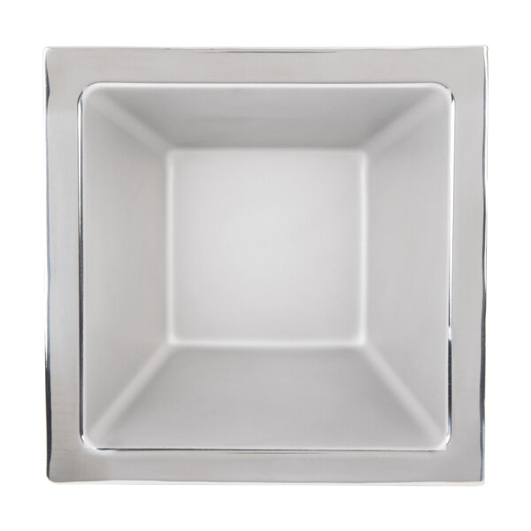A white square bowl with stainless steel trim.
