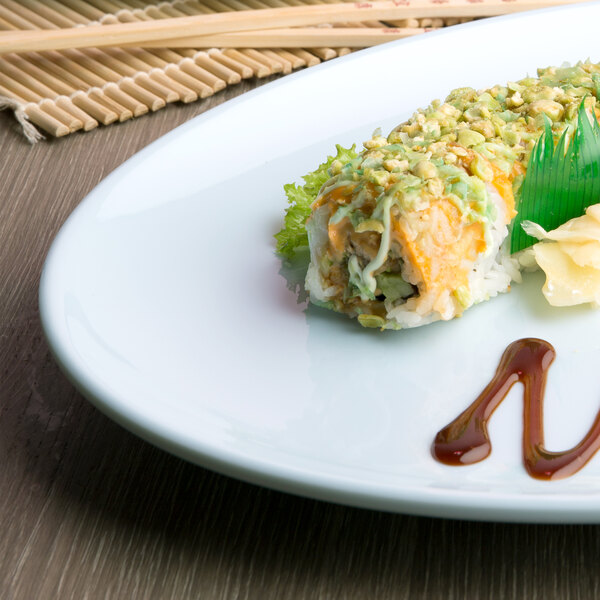A sushi roll with sauce and vegetables on a Thunder Group Blue Jade oval melamine platter.