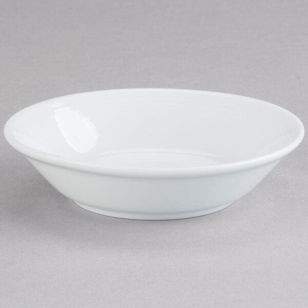 An Arcoroc white china bowl on a gray surface.