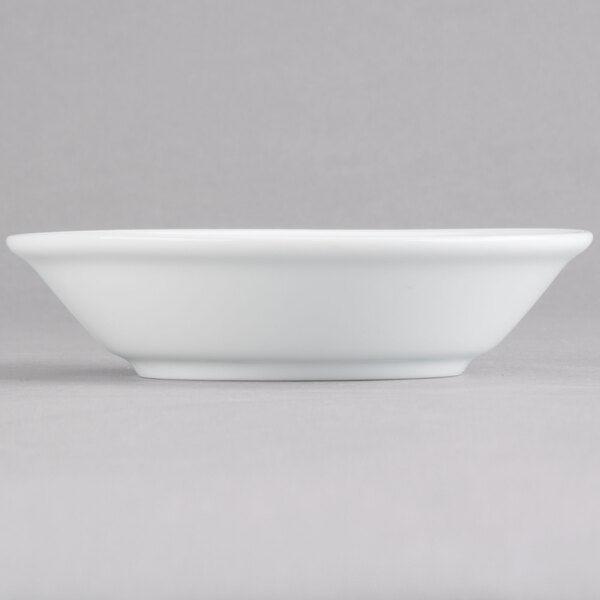 An Arcoroc Rondo white bowl on a gray surface.