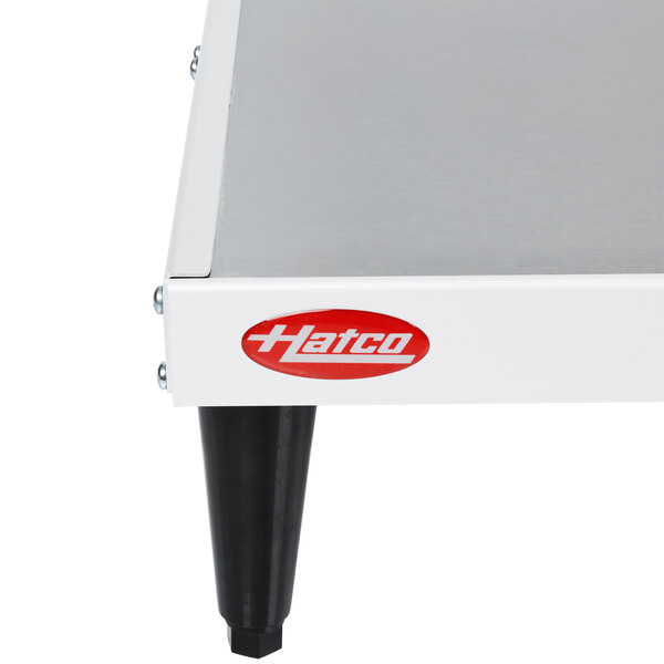 A white and black metal Hatco heated shelf on a table.