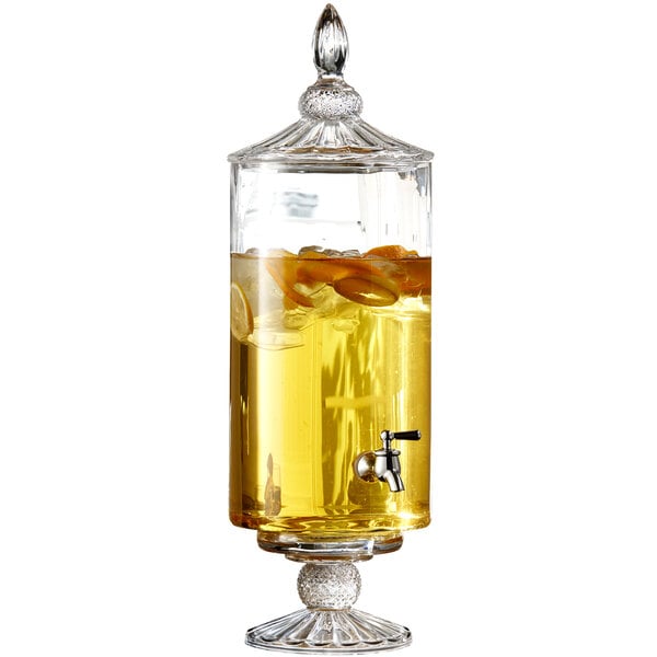 A Jay Companies Westchester glass beverage dispenser filled with liquid, ice, and orange slices.