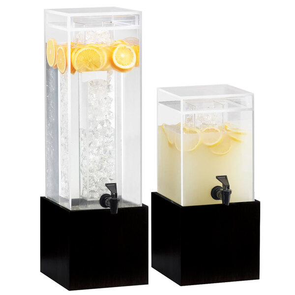A couple of Cal-Mil black square bases for glass beverage dispensers filled with water, lemons, and ice.