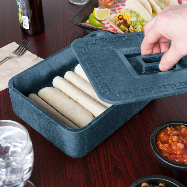 A person putting burritos into a blue HS Inc. multi-purpose container.