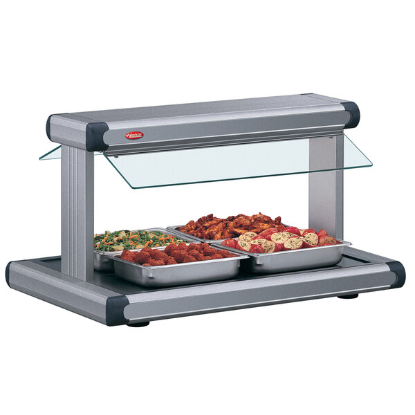 A Hatco countertop buffet warmer with gray granite insets over food on a counter.