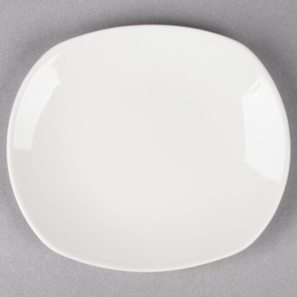A Tuxton Napa AlumaTux Pearl White china plate on a gray surface.