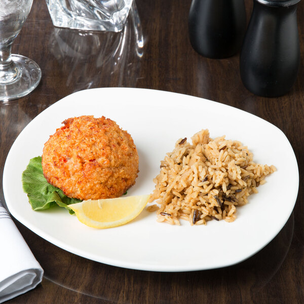 A Tuxton Pearl White china plate with rice and meat on it.