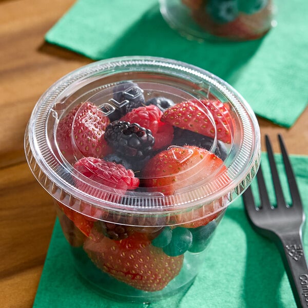 A clear plastic lid covering a cup filled with assorted fresh berries.